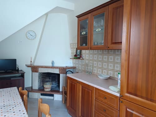 Cucina rustica con mobili in legno, camino e piastrelle decorative in appartamento abruzzese