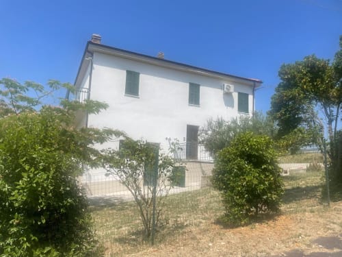 Casa bianca a due piani dell'hotel Tales of Abruzzo ad Atessa, Italia, circondata dal verde e un cielo azzurro limpido