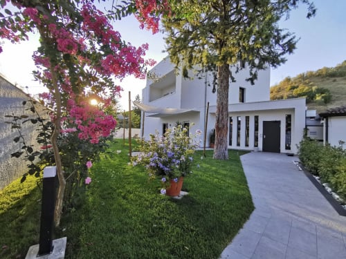 Green Land Boutique Hotel a Castilenti vanta un'architettura moderna bianca, giardini lussureggianti con vivaci buganvillee magenta,