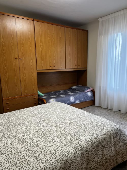 Camera da letto con due letti singoli, armadio in legno e scaffali integrati nell'appartamento Tales of Abruzzo ad Atessa