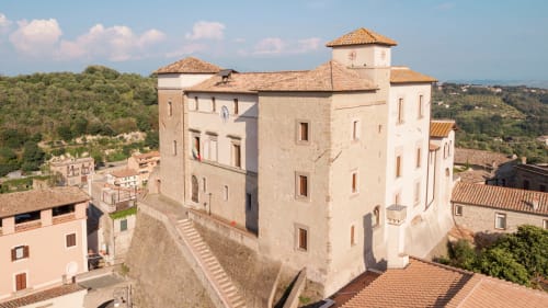 Storico castello-hotel a Campagnano di Roma con tetti in cotto, torri in pietra e vista sulla campagna italiana