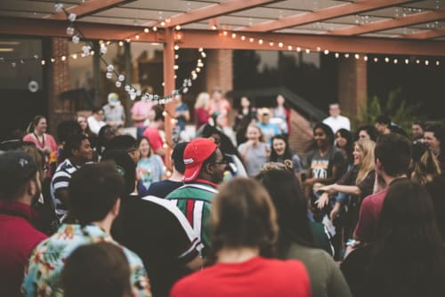 Festa sulla terrazza di Co-Host Now a Campagnano di Roma con ospiti che ballano sotto le luci festose