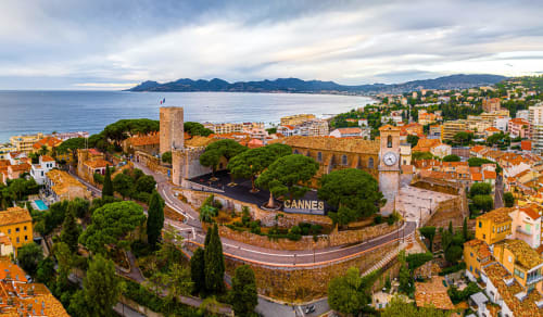 Vista aerea del castello di Cannes con il Mare Mediterraneo, tetti in terracotta e montagne costiere della Francia