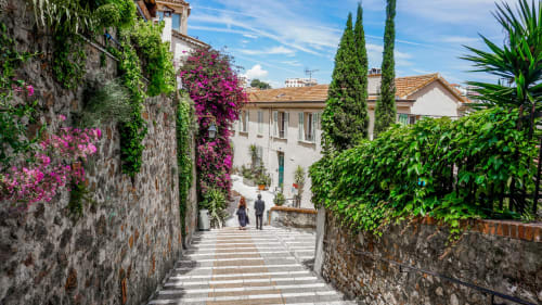 Affascinante sentiero in pietra a Campagnano di Roma con muri ricoperti d'edera, buganvillea fucsia e architettura tradizionale italiana