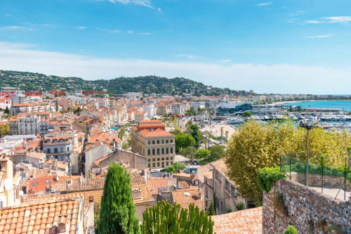 Vista aerea di Cannes con tetti in terracotta, costa mediterranea e porto