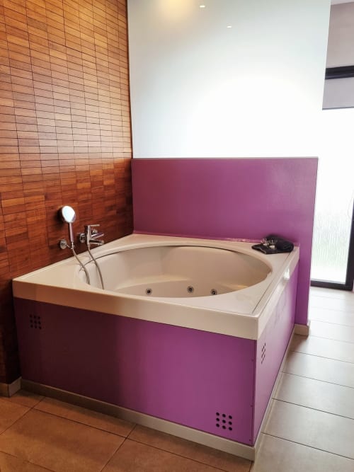 Modern jacuzzi bathtub with purple surround in luxury apartment Lila at El Arrecife de Conil, Conil de la Frontera