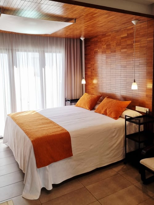 Naranja apartment bedroom at El Arrecife de Conil with orange accent wall, double bed, pendant lights, and private terrace in