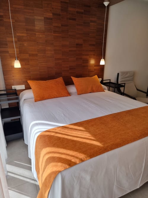 Bright bedroom in El Arrecife de Conil, Conil de la Frontera, with double bed, orange accents, wooden headboard and pendant