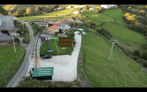 Vista aérea de propiedad rural en Asturias con piscina al aire libre, aparcamiento y montañas cerca de Biescas