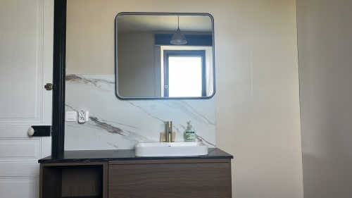 Lavabo moderne avec dosseret en marbre et miroir arrondi dans la Suite Signature La Poterne, Épernay