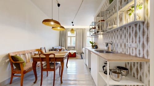 Modern kitchen and dining area in tARTu Stays apartment with wooden table, pendant lights, and city view in Tartu