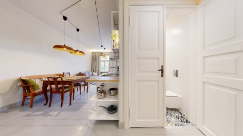 Modern Tartu apartment with dining area, wooden table, kitchen, and white pendant lights