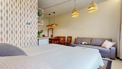 Modern studio apartment at tARTu Stays with bed, gray sofa, pendant lights, and city views in Tartu