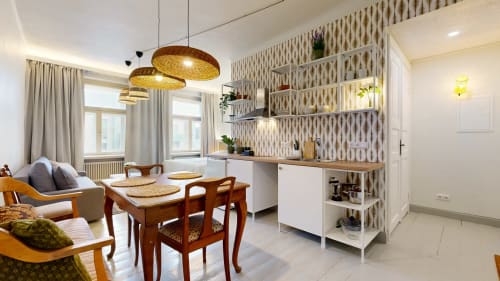 Modern apartment at tARTu Stays with open kitchen, dining area, woven pendant lights, and city views in Tartu, Estonia.