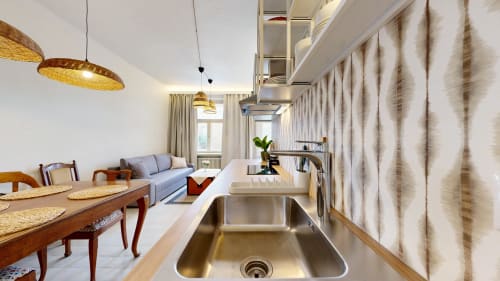 Modern open-plan kitchen and living area at tARTu Stays, Tartu, with stainless steel sink, wooden dining table, and city