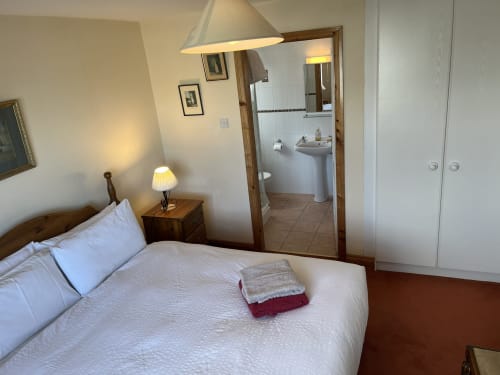 Bedroom in Ard Na Mara apartment at Bucket & Spade, Co. Clare with bed, ensuite bathroom, and coastal decor