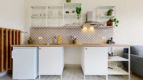 Modern kitchen in tARTu Stays apartment with white cabinets, patterned backtile, wooden counter, and open shelving with