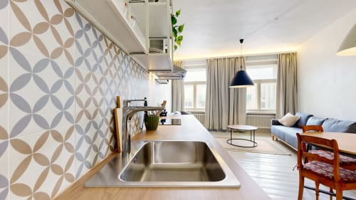 Modern studio apartment in Tartu with open kitchen, dining area, and city view from windows