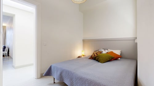 Modern bedroom at tARTu Stays apartment in Tartu with blue bedding, colorful pillows, and minimalist design