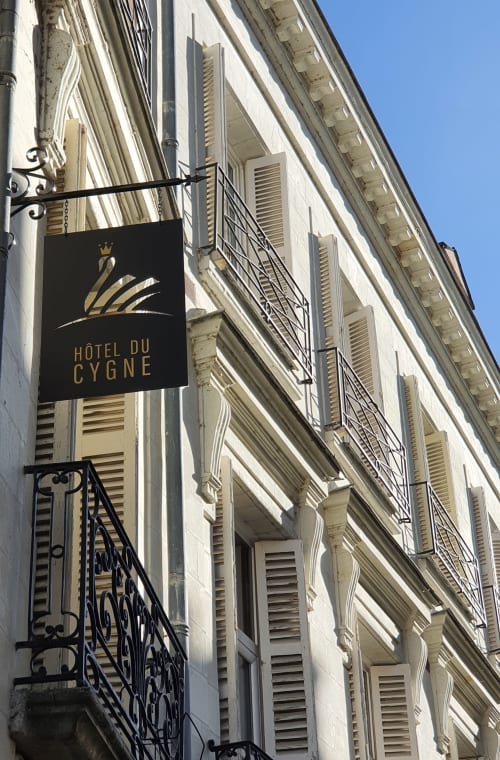 Enseigne de l'Hôtel Du Cygne sur la façade d'un immeuble de style parisien classique à Tours, France