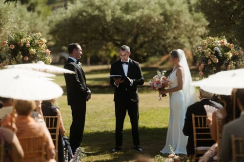 Outdoor wedding ceremony at Le Domaine du Fortin in Ménerbes with bride, groom, and officiant
