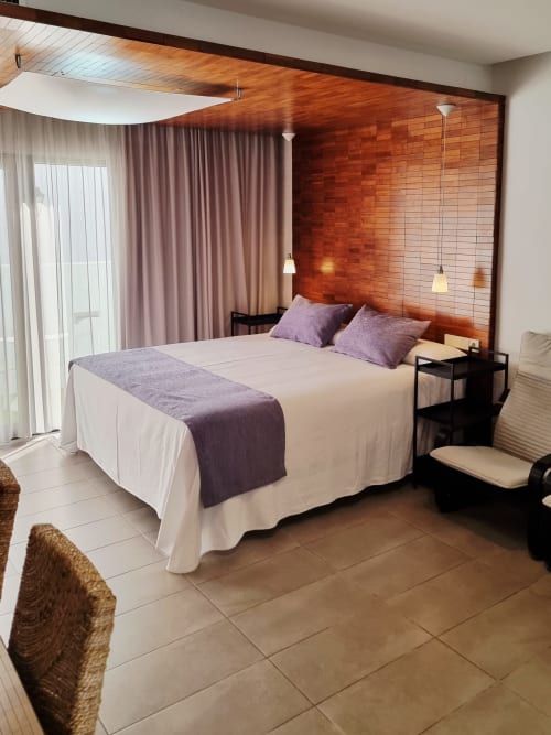 Modern bedroom with wooden headboard, purple accents, and city views at El Arrecife de Conil, Conil de la Frontera