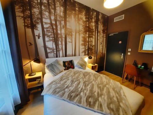 Chambre moderne à l'Hôtel Du Cygne à Tours avec fresque forestière, lit queen-size, éclairage chaleureux et décoration minimaliste