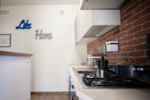 Modern kitchen with gas stovetop, moka pot, and cookware in LikeHome villa near Ferrara coast