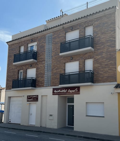 Apartamentos Turísticos Raquel's exterior in Sant Pere Pescador, brick apartment hotel with balconies and ground floor
