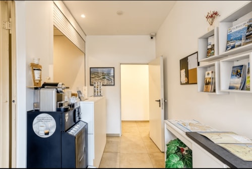 Modern hotel room kitchenette with coffee machine, shelving, and doorway at Apartamentos Raquel's in Sant Pere Pescador