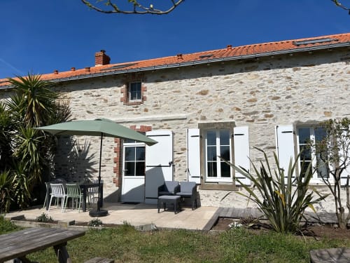 Stenen cottage Gîte Les Plages in Le Pré d'Olonne met tuinterras, parasol, zitplaatsen en tropische planten