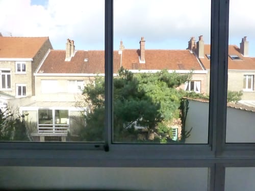 Vue depuis l'appartement Résidence malouine à Dunkerque montrant les maisons voisines et le jardin, à 5 minutes de la plage
