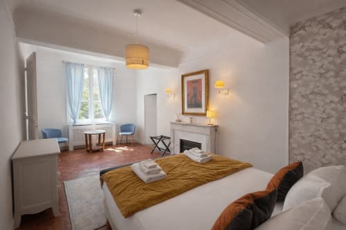 Les Suites de Montigny Suite Mirabeau bedroom with twin beds, fireplace, and garden views in Aix-en-Provence