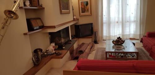 Soggiorno dell'appartamento Tales of Abruzzo ad Atessa, con divano rosso, TV, zona lavoro e vista sulla città