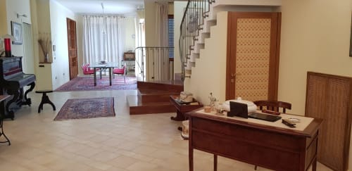 Ampio soggiorno dell'appartamento Tales of Abruzzo ad Atessa, con scrivania in legno, scala e vista sulla città