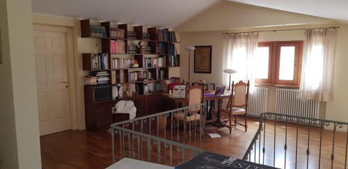 Ampio soggiorno ad Atessa con arredi in legno, libreria, tavolo da pranzo e balcone con vista sulla città