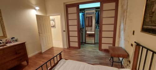 Camera da letto nell'appartamento Tales of Abruzzo, Atessa con pavimento in legno, letto, cassettone, scrivania e armadio aperto