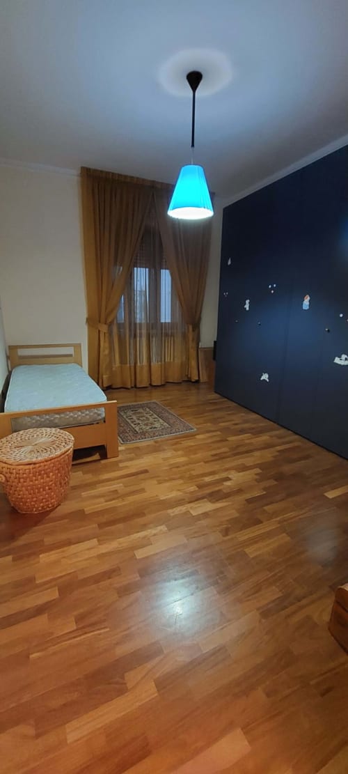 Camera da letto moderna al Tales of Abruzzo ad Atessa con pavimento in legno, lampada a sospensione blu, letto in legno, parete scura e