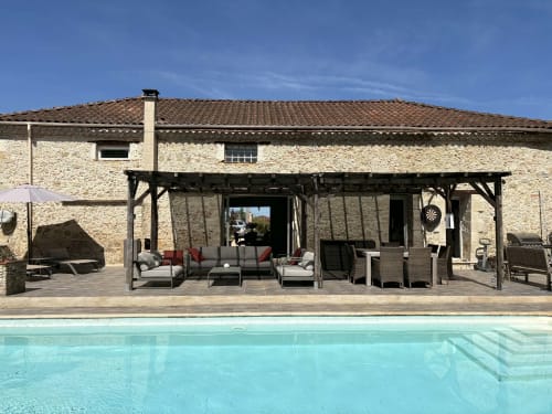 Le Jardin d'Elusa B&B à Eauze : maison en pierre avec terrasse couverte, salon de détente et piscine