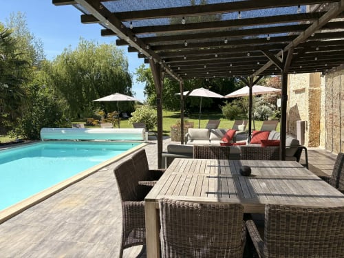 Espace piscine du Jardin d'Elusa avec tables de restauration, pergola et jardins paysagés à Eauze