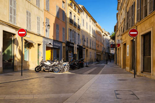 Charming street in Aix-en-Provence with yellow buildings, no entry signs, and parked motorcycles