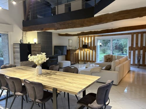 Espace ouvert de dining et séjour moderne au Gîte Le Jardin d'Elusa à Eauze, avec poutres en bois et vue sur le jardin