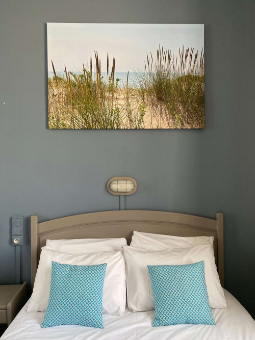 Coastal bedroom at Hôtel Maison Richet with beach dune artwork, taupe bed frame, white linens, and turquoise patterned