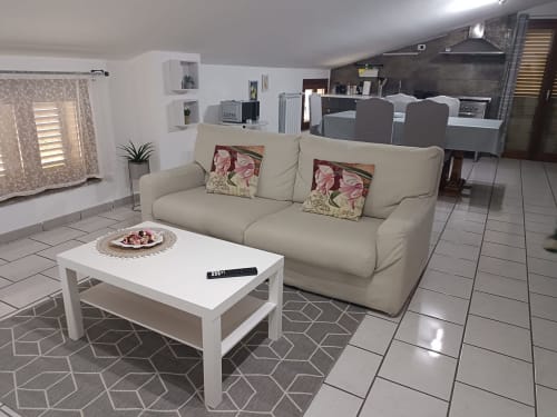 Ampio soggiorno dell'hotel Tales of Abruzzo ad Atessa con divano color crema, tavolino bianco e arredi moderni