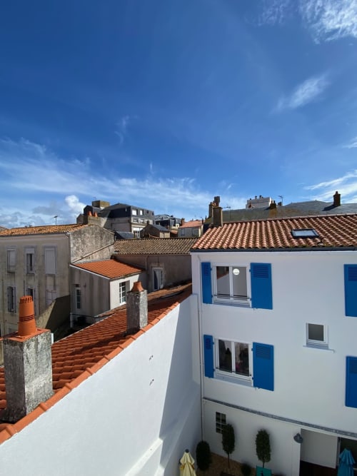 White building with blue shutters overlooking terracotta rooftops in Les Sables-d'Olonne