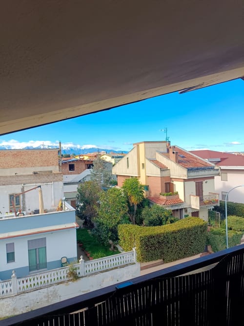 Colorful residential buildings in Atessa with snow-capped mountains in distance, city view from Tales of Abruzzo apartment