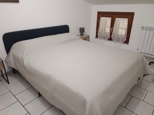 Spacious bedroom at Tales of Abruzzo with double bed, dark headboard, and French doors at TRA MARE E MONTI apartment in
