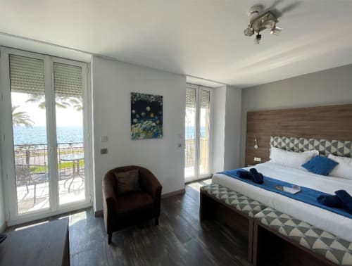 Chambre luxueuse avec vue panoramique sur la Méditerranée à l'Hôtel Flots d'Azur Nice, balcon et mobilier moderne