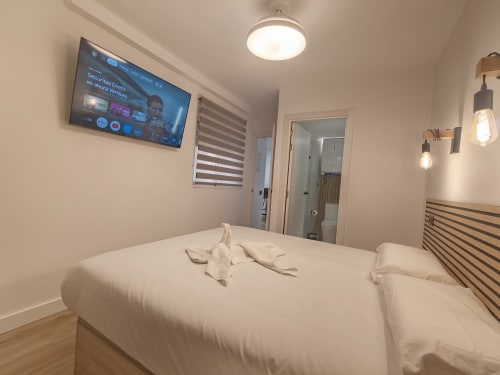 Habitación moderna en Bahia Mar Canarias, Telde con vistas al mar, TV de pantalla plana, persianas rayadas y mobiliario contemporáneo