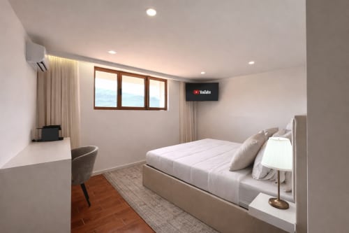 Quarto moderno da Quinta das Susandas com cama queen, escrivaninha, TV, janelas com vista para montanhas e design contemporâneo